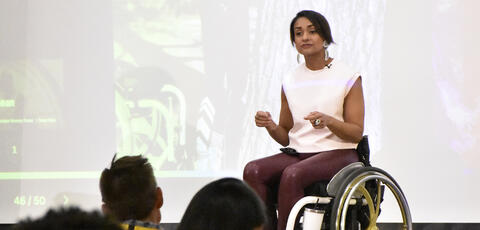 Women in wheelchair speaking in front of conference