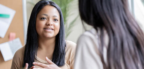 Young women speaking to a peer