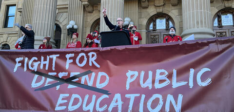 Jason Schilling stands in front of a crowd at a rally