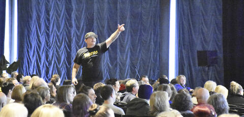 A man speaks to a group of people at a conference