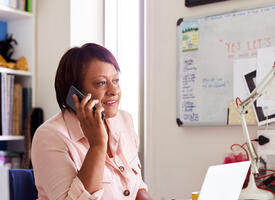Mature women sitting at desk on the phone