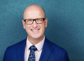 ATA president, Jason Schilling standing in a blue suit in front of a blue background.