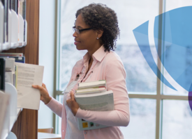 Women standing library restacking the shelves 