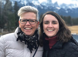 Two women posing in front of mountains