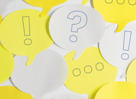 White and yellow speech bubble post-it notes with hand drawn ellipses, question and exclamation marks,