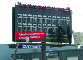 Workers install chairs on an ATA billboard