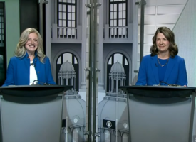 NDP and UCP leaders stand at podiums with blue blazers