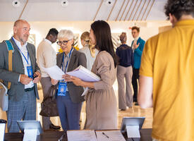 Three peoples standing at a registration desk