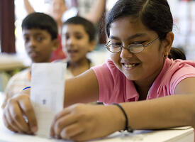 A student places a vote in a ballot box