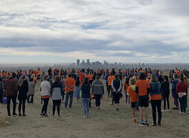 Attendees at a Truth and Reconciliation event look towards a city landscape