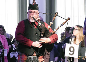 A bagpiper walks into the assembly kicking off this year's ARA