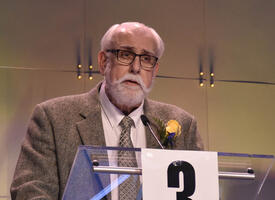 ATA suporter, Richard Rand stands at a podium at a past ARA