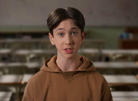 Male student in brown hoodie speaking to the camera
