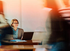 Teacher sitting at front of class as students leave classroom