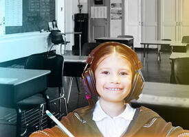 Girl wearing headphones in front of a black and white classroom