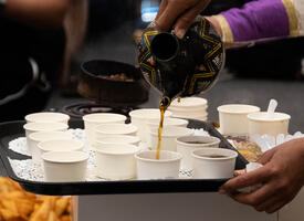 Coffee being poured into small sample paper cups