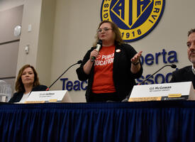 Four NDP candidates sit at table speaking at the Local Communications Officers meeting