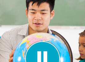 Young male teacher shows off globe to students