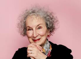 Women with curly grey hair clasping her hands at chin