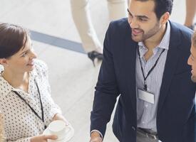 Two men and two women convene in a conference hall