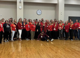 group of 25 people wearing red shirts in the ATA's auditorium