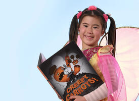 A young person holding a copy of a book titled Creepy Carrots 