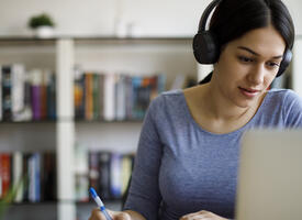 women with headphones on laptop