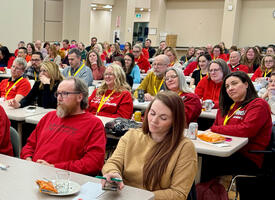 Group wearing red shirts for education seated in a seminar