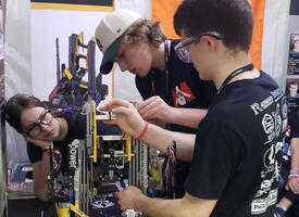 Students working on a robot in a shop
