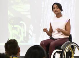 Women in wheelchair speaking in front of conference
