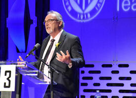 Man in suit speaks at ARA podium