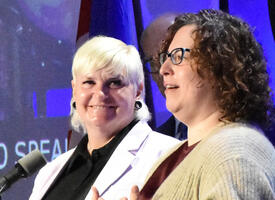 Women receiving award from another women on ARA stage.