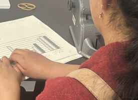 Student at desk reading braille 