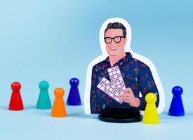 An illustrated boardgame player piece of Sandy Johnson stands among a colourful collection of more generic conical player pieces. Sandy is wearing glasses, smiling, and holding up a math game with numbers in a chart..