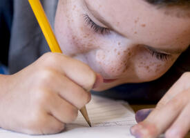 Close up of a child writing an exam