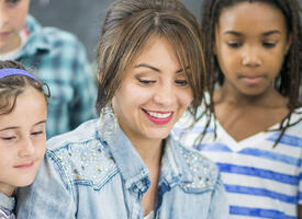 Female teacher surrounded by grade 4 class