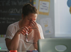 Tired teacher sitting at a desk