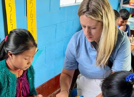 A teacher explains a math lesson to Guatemalan students