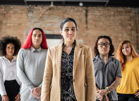 Group of individuals standing in a flying V in a warehouse