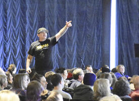 A man speaks to a group of people at a conference