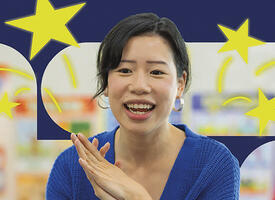 Image of a teacher in front of a bulletin board