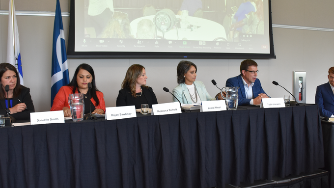UCP Leadership candidates sitting along a table speaking in front of teachers at Summer Conference