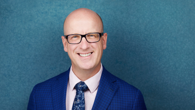 ATA president, Jason Schilling standing in a blue suit in front of a blue background.