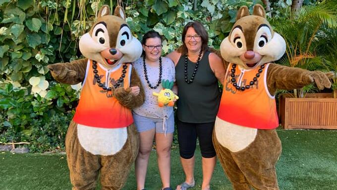 Two women pose with Disney's Chip and Dale characters