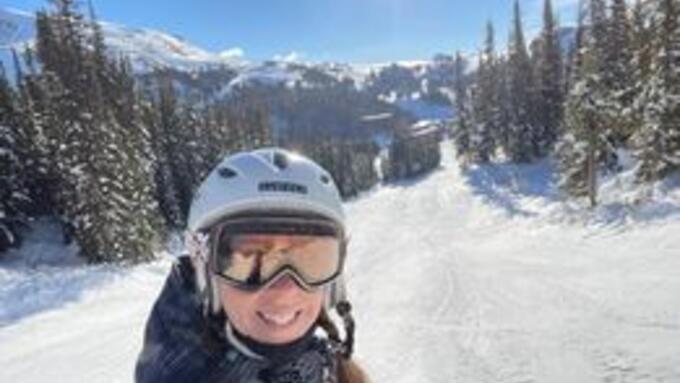 A skier on a run with the mountains in the background