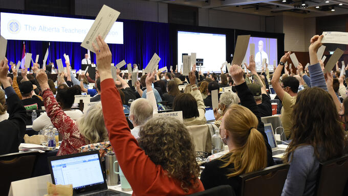 Room full of individuals voting with their hands raised at the 2022 Annual Representative Assembly