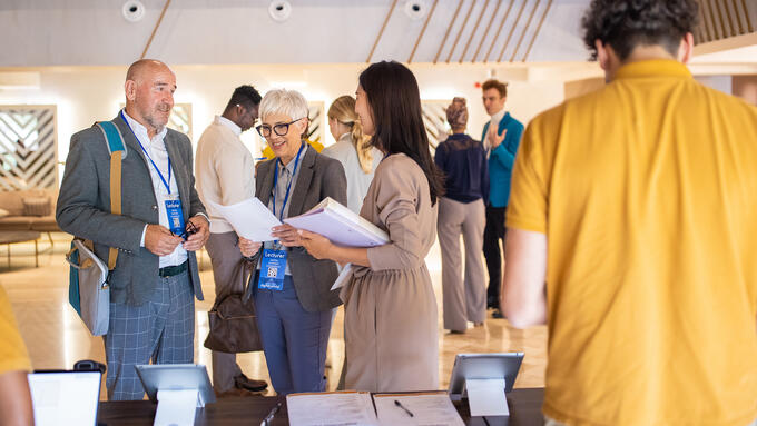 Three peoples standing at a registration desk