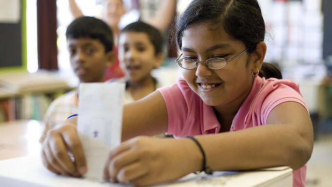 A student places a vote in a ballot box