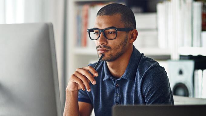 Man in glasses sitting at computer at home