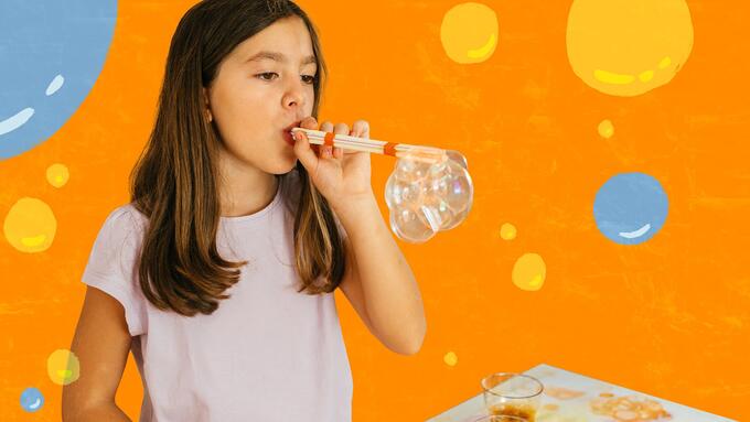 Girl blowing bubbles through a straw